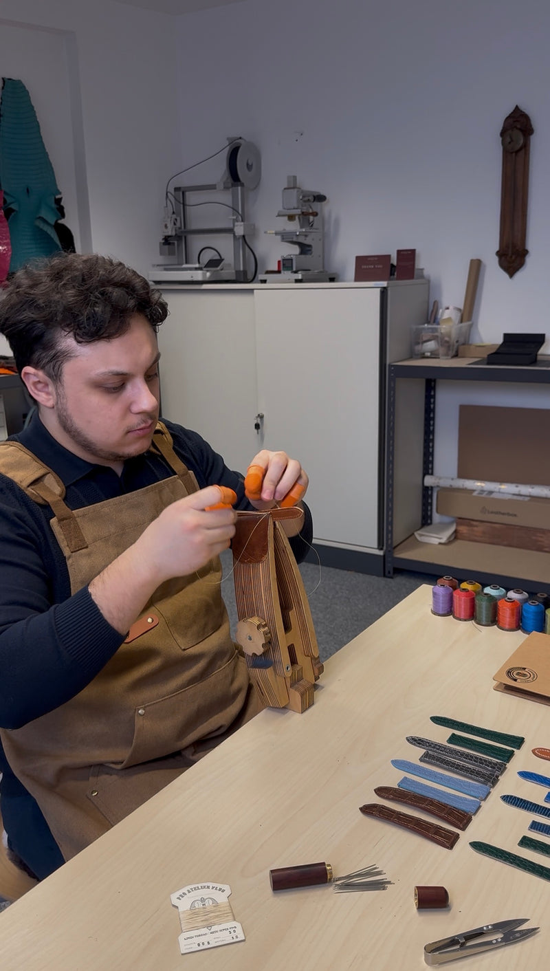 Ein Armband wird an der Werkbank im Sattlerstich von Hand genäht