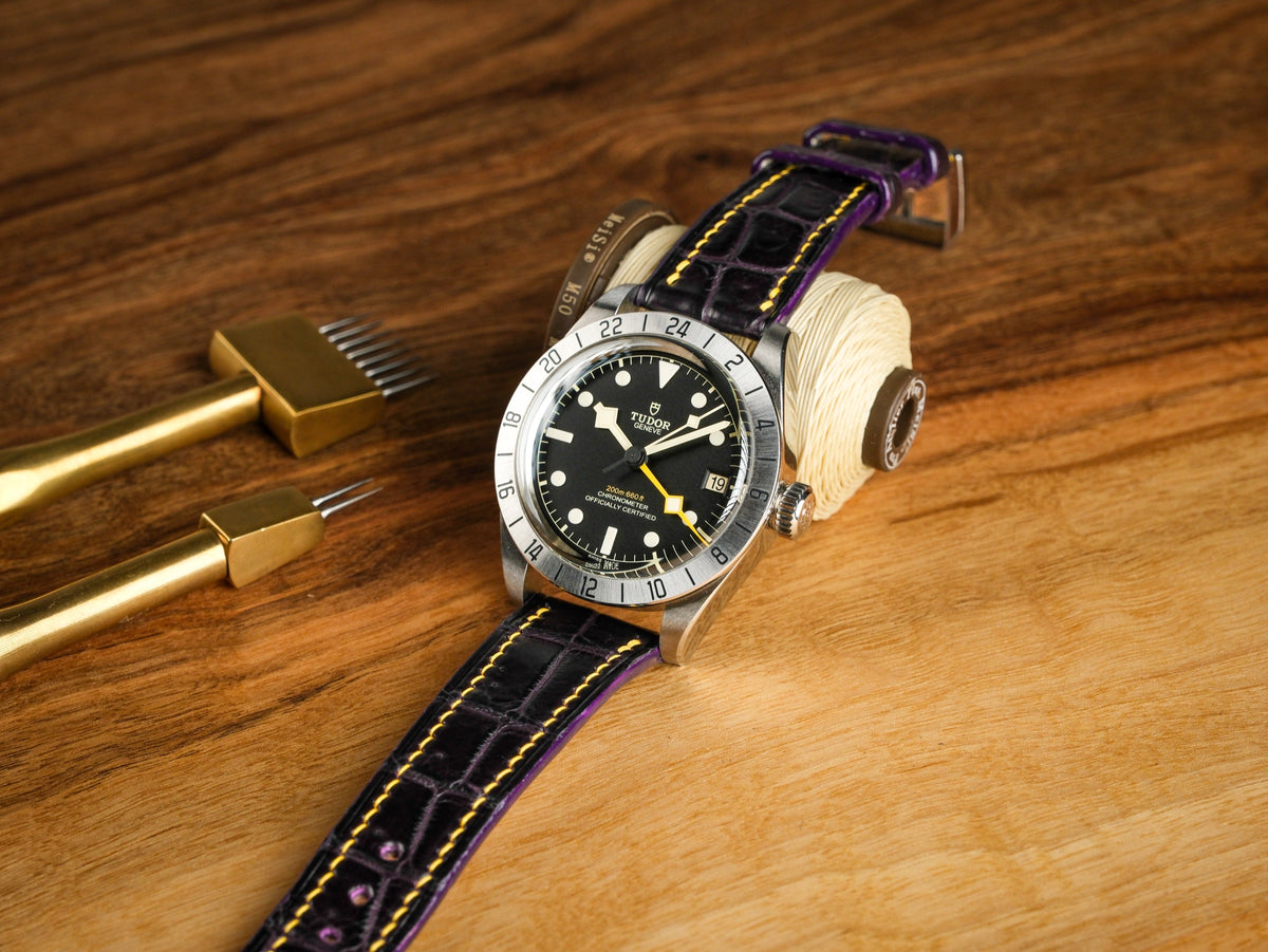 Purple alligator strap with yellow stitching on a Tudor Black Bay Pro