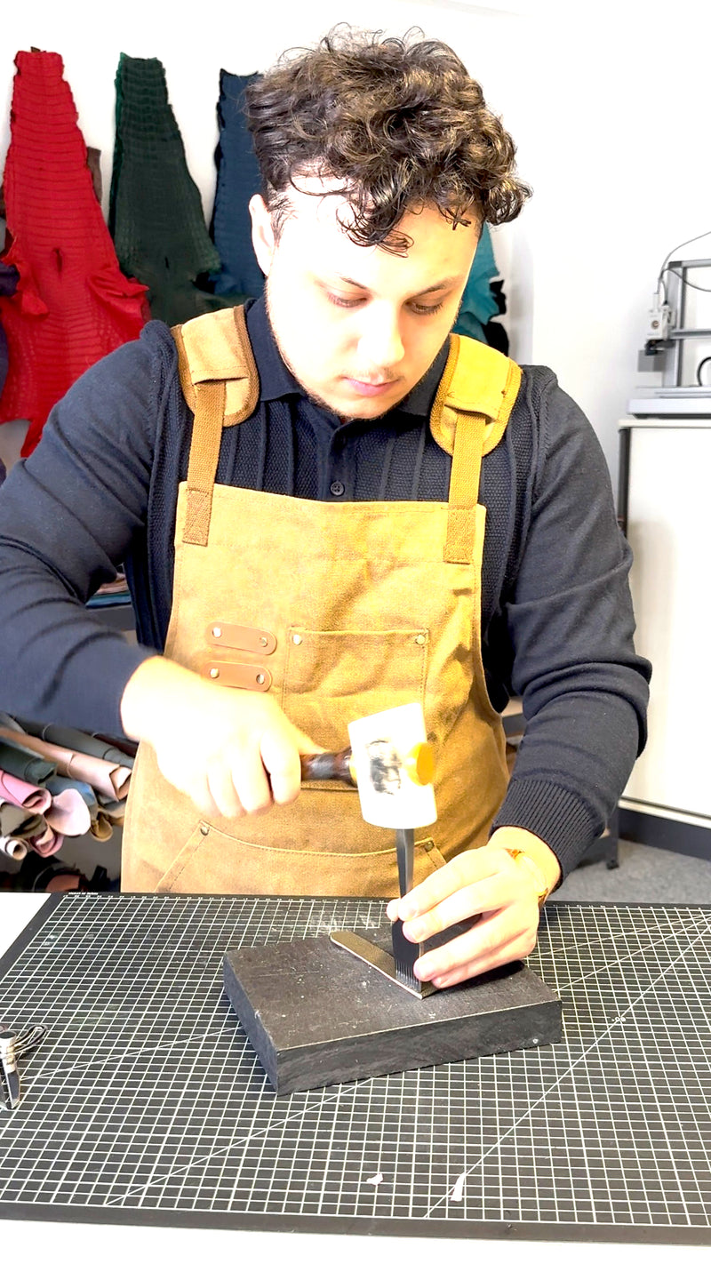 Nahtlöcher werden mit dem Hammer in ein Armband gestochen